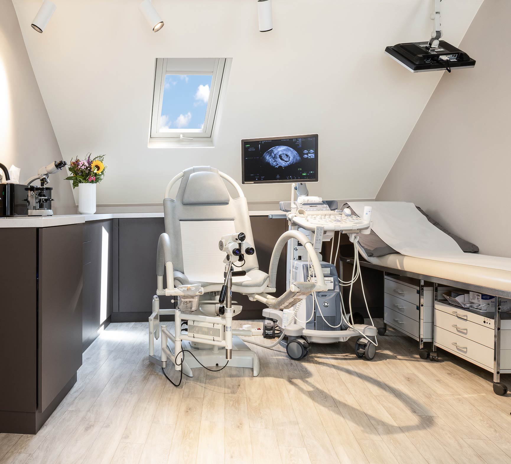 Modern eingerichtetes Behandlungszimmer mit Screen und gynäkologischem Stuhl in einer Frauenarztpraxis Münchens Zentrum.