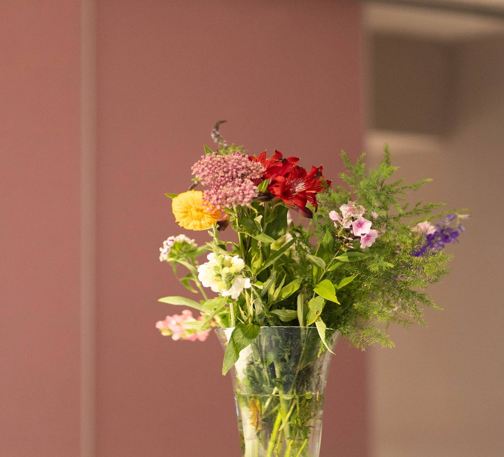 Close up eines schönen Blumenstrauses in rosa und rot Tönen in einer Praxis, einer Frauenärztin in München.